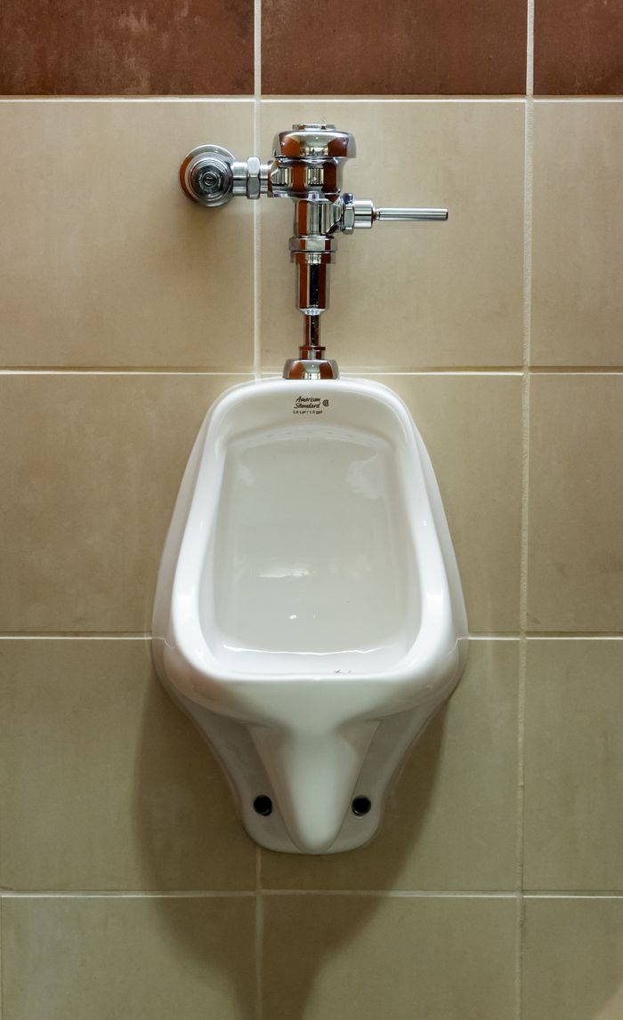 Crafting Captivating Headlines: Your awesome post title goes here Close-up view of a wall-mounted urinal in a public restroom, showcasing plumbing fixture.